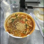 A bowl of soup with a spoon in it.