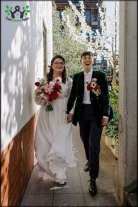 A bride and groom are walking down the aisle, holding hands and smiling.