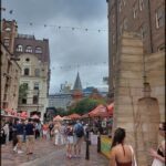 A busy city street filled with people walking and enjoying the day.