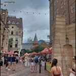 A busy city street filled with people walking and enjoying the day.
