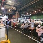 A busy restaurant with people sitting at tables and enjoying their meals.