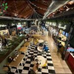 A busy restaurant with people sitting at tables and enjoying their meals.