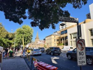 A busy street with cars and people, and a street sign that says "Salamanca P."
