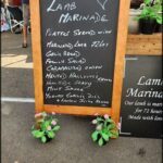 A chalkboard menu lists various dishes, including lamb marinated.