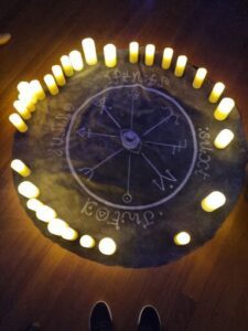 A circle of candles with a circle of letters in the middle.