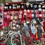 A collection of watches and jewelry are displayed on a table, including a variety of bracelets and necklaces.