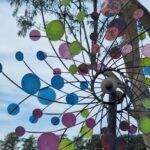 A colorful windmill with a yellow center and blue and yellow circles around it.