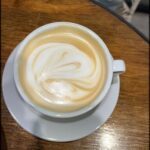 A cup of coffee with a heart shaped foam on top.