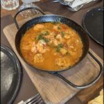 A delicious seafood dish is served in a black pan, ready to be enjoyed.