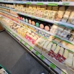 A display of cheese in a grocery store.