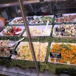A display of various salads and vegetables in a store.