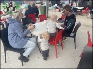 A family of four, including two children, sit around a dining table.