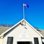A flag flies high above a building, representing the country it belongs to.