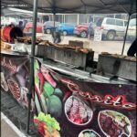 A food stand with a sign that says "Territorio" is selling a variety of foods, including meat and vegetables.