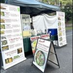 A food truck with a menu board and a tent.