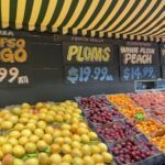 A fruit stand with a variety of fruits, including apples, oranges, and lemons.