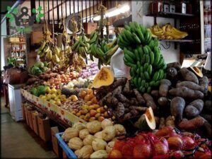 A fruit stand with a variety of fruits including bananas, apples, and oranges.