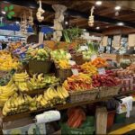 A fruit stand with a variety of fruits including bananas, oranges, and apples.