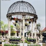 A garden with a gazebo and a fountain.