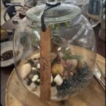 A glass vase with a wooden tag that says "Cole" on it.
