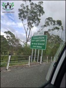 A green sign on a pole with the words "Caboolture Exit" on it.