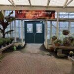 A greenhouse with a sign that says "Celebrate Every Season at Squak Mountain."