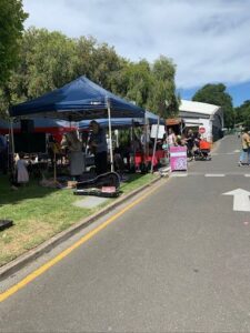 A group of people are gathered around a tent, playing music and enjoying the outdoors.