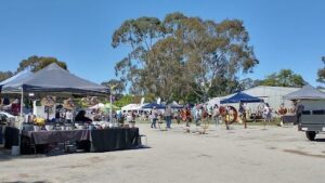 A group of people are gathered around a tree, enjoying the outdoors.