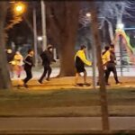 A group of people are running in a park at night.