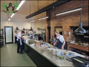 A group of people are working in a kitchen, preparing food.
