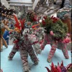 A group of stuffed animals are displayed on a table, including a dog with a red tongue.