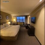 A hotel room with a bed, chair, and television.