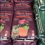 A large bag of Tim's Best Potting Mix sits on a table, ready to be used for gardening.