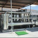 A large metal pipe is located in a building, possibly a factory or warehouse.