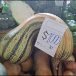 A large, odd-shaped vegetable with a price tag of $1000 sits on a table surrounded by other vegetables.
