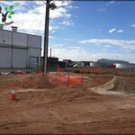 A large orange fence is set up around a construction site.