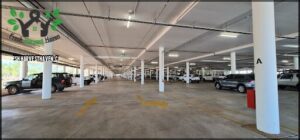 A large parking garage with a row of parked cars.