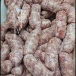 A large pile of sausages are displayed in a store.