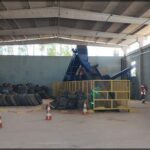 A large pile of tires is being processed in a warehouse.