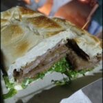 A large sandwich is cut in half and ready to be eaten.