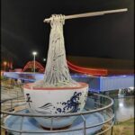 A large white bowl with a blue design is sitting on a platform.