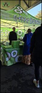 A man and a woman are standing in front of a table with pizza boxes on it.