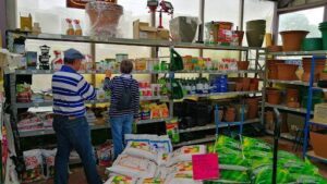 A man and woman are shopping for plants at a nursery.