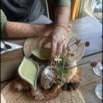 A man is holding a plate with a flower arrangement on it.