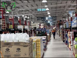 A man is walking through a store with a box on his head.