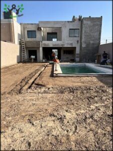 A man is working on a pool in a backyard.
