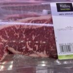 A package of raw beef sits on a table, ready to be cooked.