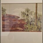 A painting of a palm tree and a rocky hillside.