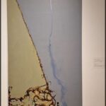 A painting of a waterfall with a blue streak.