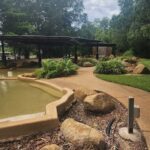 A park with a pond and a pathway.